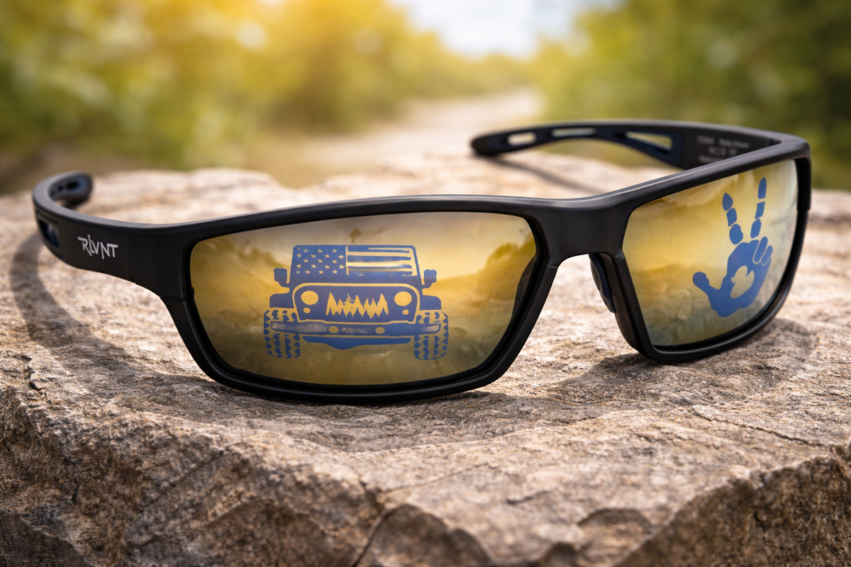 Sunglasses with reflective blue design on a boulder with blurred natural background